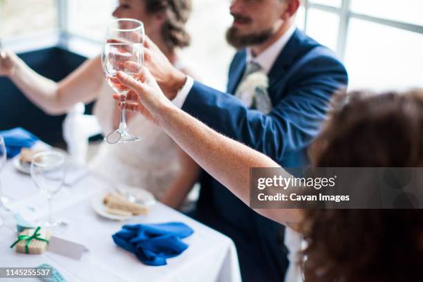 high angle view of newlywed couple toasting drinks while sitting in restaurant - bride groom toast stock pictures, royalty-free photos & images