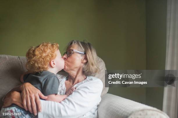 grandmother and grandson kissing on mouth at home - embrasser sur la bouche photos et images de collection