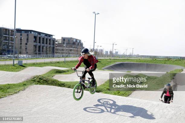 female cyclist beating friend in race on bmx - london olympic park stock-fotos und bilder