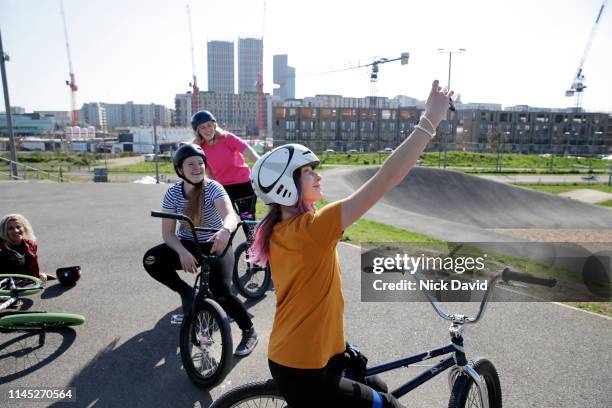 candid portrait of female cyclist taking selfie on bmx race track - bmx track london stock pictures, royalty-free photos & images