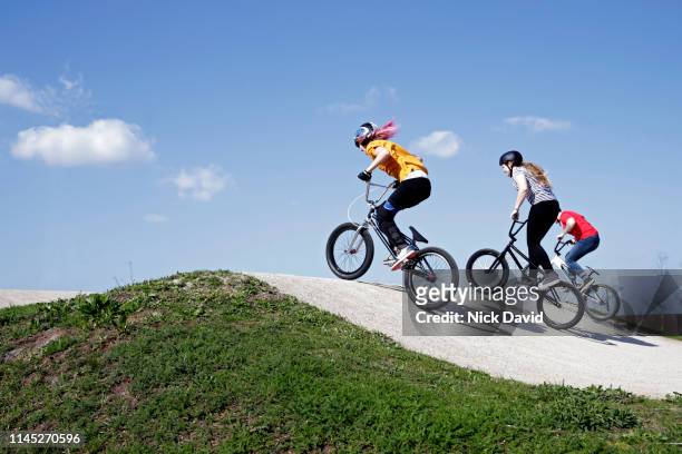 young women racing bmxs on racing track - bmx track london stock pictures, royalty-free photos & images