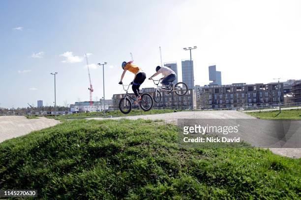 two young women mid air on bmx bikes - bmx track london - fotografias e filmes do acervo