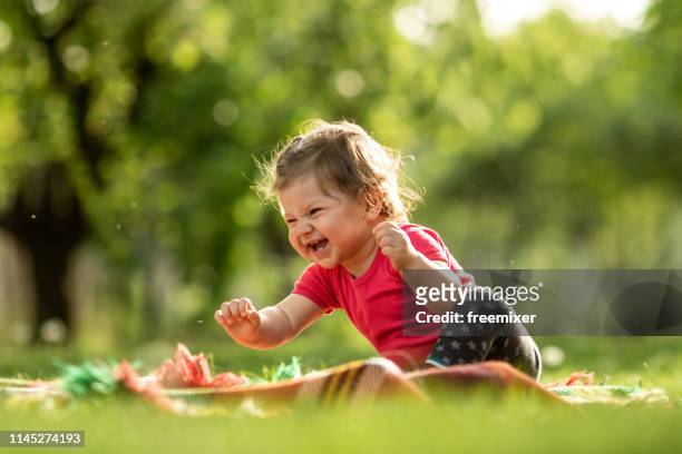 baby boy spielt im gras - baby lachen natur stock-fotos und bilder