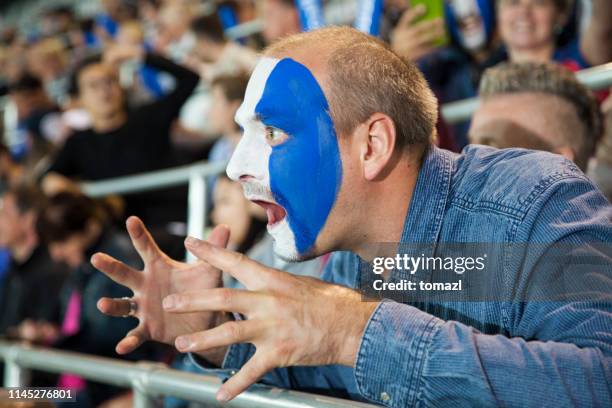 junger mann fußball-fan mit gesicht in vereinsfarben gemalt - club football stock-fotos und bilder