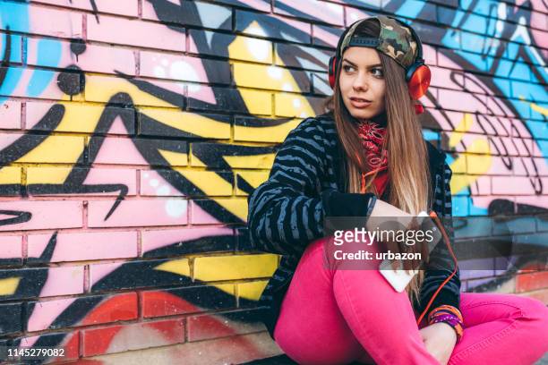 urban jonge vrouw luisteren naar muziek - fashion pretty woman listening music in headphones with smartphone colorful stockfoto's en -beelden