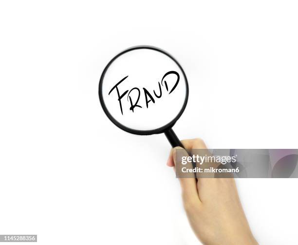 looking though a magnifying glass onto fraud - bank fraud stock pictures, royalty-free photos & images