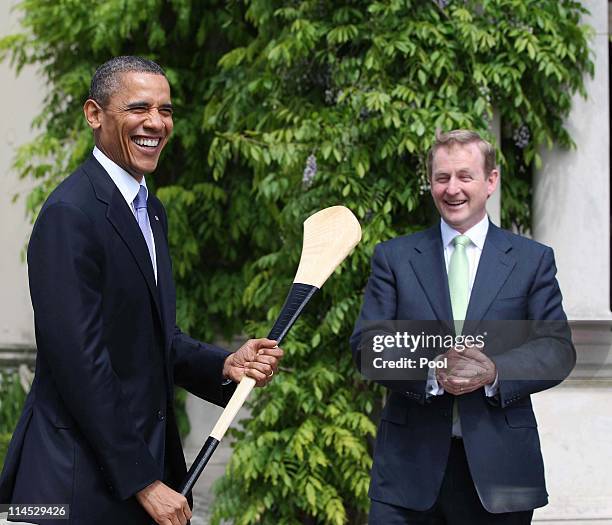 President Barack Obama holds a hurley after it was given to him by Irish Prime Minister Taoiseach Enda Kenny at Farmleigh May 23, 2011 in Dublin,...