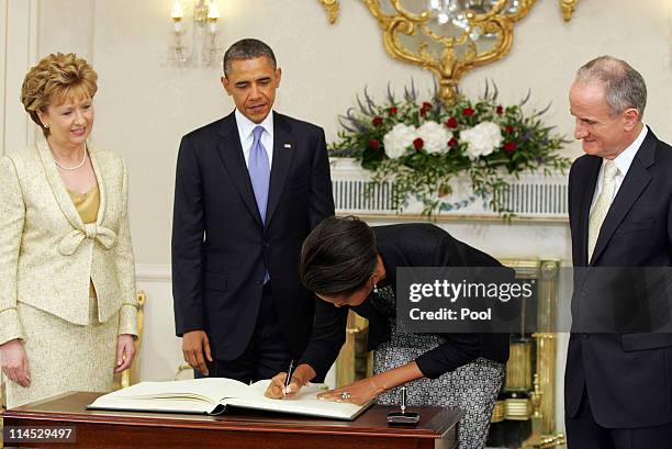 Irish President Mary McAleese, U.S. President Barack Obama and Dr. Martin McAleese watch as first lady Michelle Obama signs the visitor's book at...