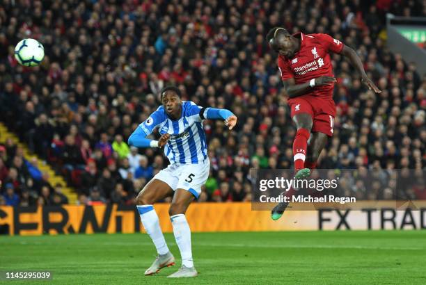 Sadio Mane of Liverpool scores his team's second goal as Terence Kongolo of Huddersfield Town challenges during the Premier League match between...