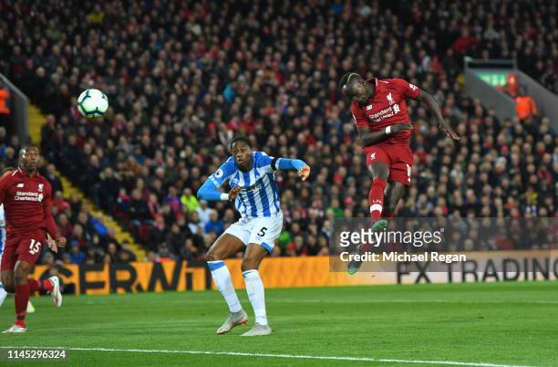 Sadio Mane of Liverpool scores his team's second goal as Terence Kongolo of Huddersfield Town challenges during the Premier League match between...