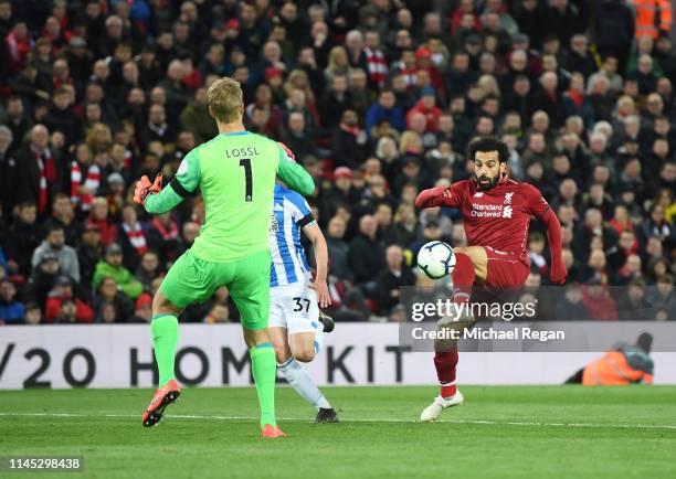 Mohamed Salah of Liverpool beats Jonas Lossl of Huddersfield Town as he scores his team's third goal during the Premier League match between...