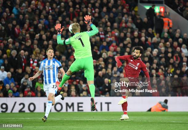 Mohamed Salah of Liverpool beats Jonas Lossl of Huddersfield Town as he scores his team's third goal during the Premier League match between...
