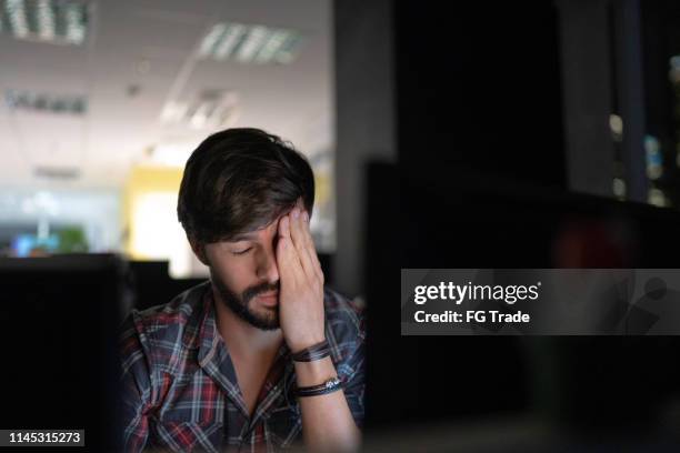 tired businessman working late and rubbing eyes - rubbing eyes stock pictures, royalty-free photos & images