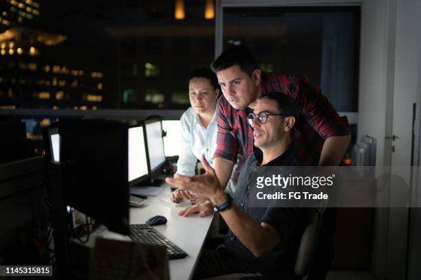dedicated team reunited working late at office - latin america technology stock pictures, royalty-free photos & images