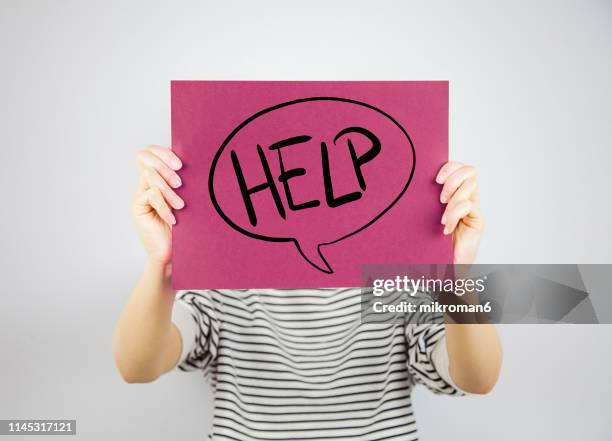 woman showing a paper page with help in a speech bobble - weakness fotografías e imágenes de stock