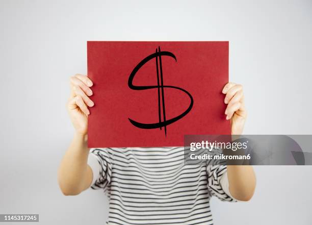 woman showing a paper with  currency sign - dollar sign photos et images de collection