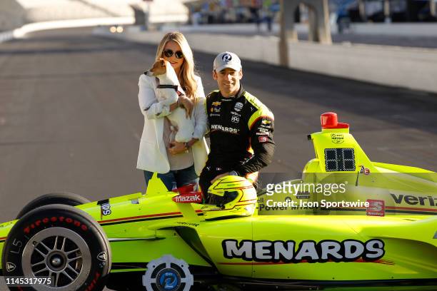 Pole winner IndyCar driver Simon Pagenaud of the Menards Team Penske Chevrolet and his fiancee Hailey McDermott along with their dog Norman during...