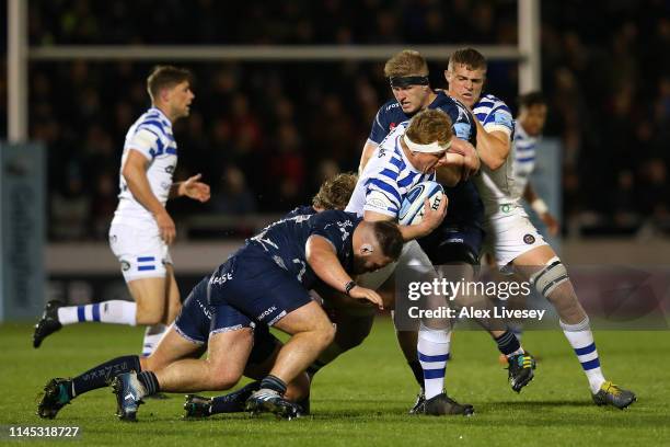 Jacques van Rooyen of Bath Rugby is tackled by Joe Jones and Matt Postlethwaite of Sale Sharks during the Gallagher Premiership Rugby match between...