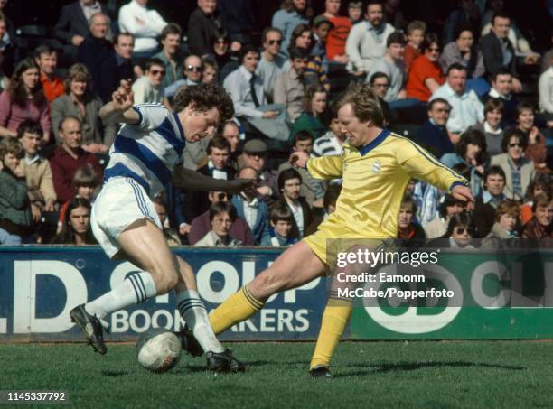 Clive Allen of Queens Park Rangers and Alan Ainscow of Birmingham City challenge for the ball during a Football League Division Two match at Loftus...