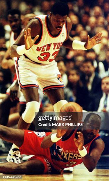 Philadelphia 76ers Moses Malone looks to pass the ball from the floor as New York Knicks Patrick Ewing looms overhead during the second quarter 09...