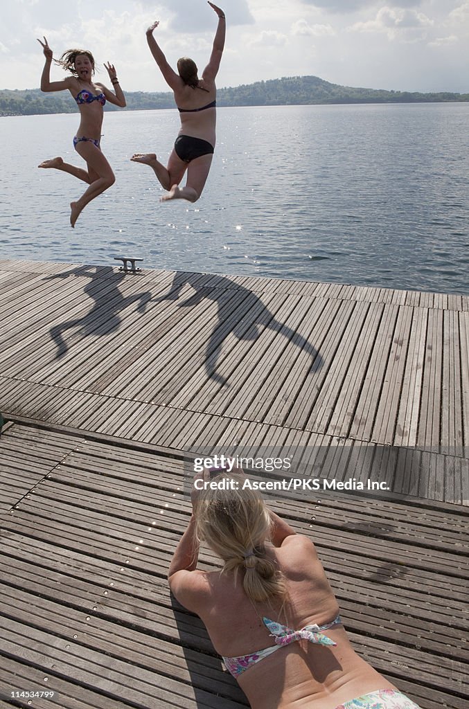 Teenage girls jump off dock as mom takes picture