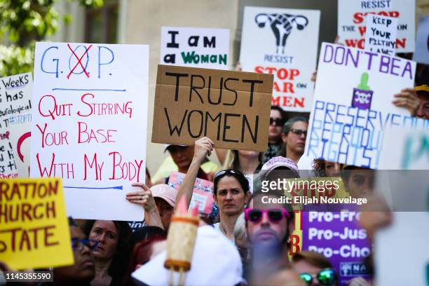 Women hold signs during a protest against recently passed abortion ban bills at the Georgia State Capitol building, on May 21, 2019 in Atlanta,...