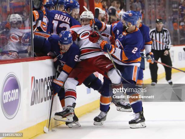 Teuvo Teravainen of the Carolina Hurricanes is sandwiched between Casey Cizikas and Nick Leddy of the New York Islanders during the third period in...