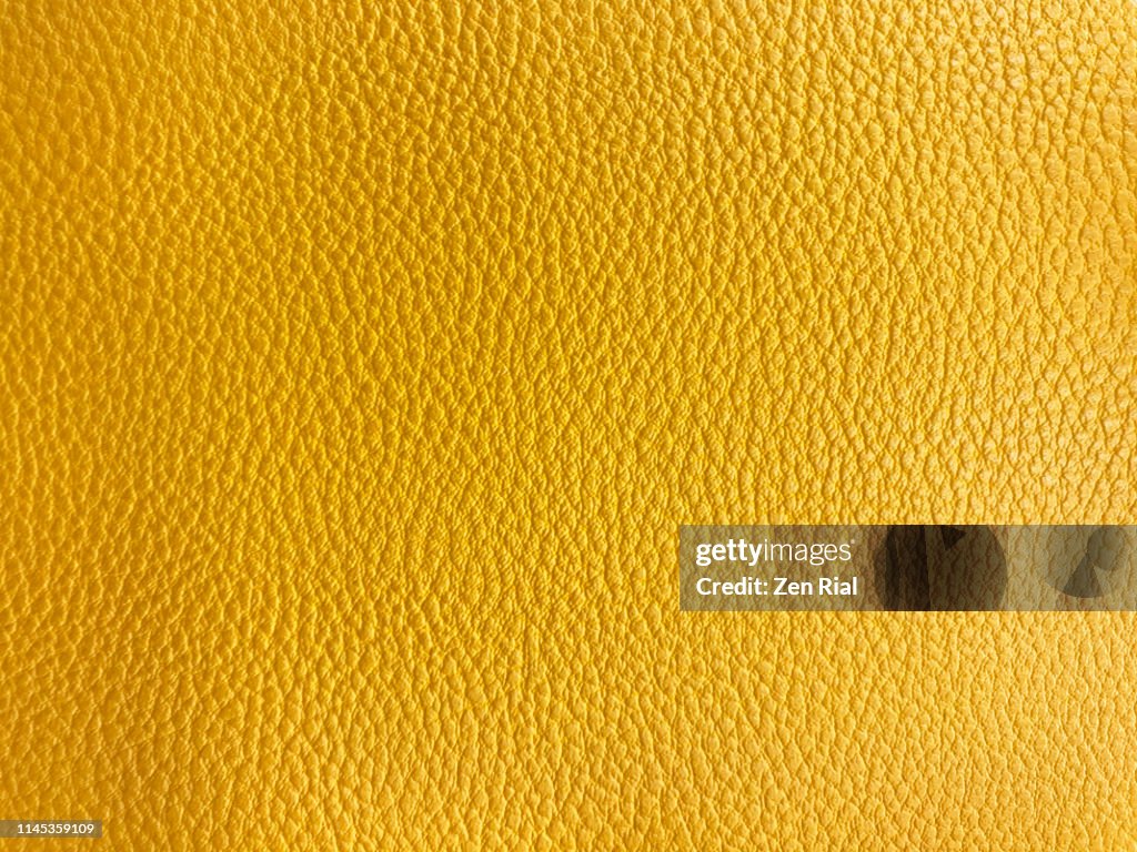Vibrant Yellow colored textured material part of a handbag
