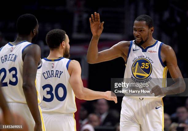 Kevin Durant of the Golden State Warriors celebrates a double digit lead lead over the LA Clippers with Stephen Curry and Draymond Green in the first...
