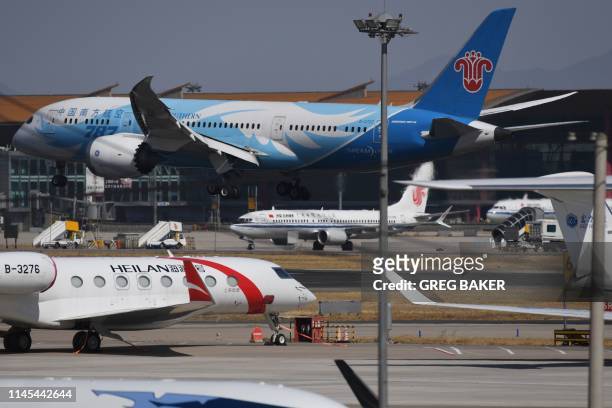 This file photo taken on March 11, 2019 shows an Air China Boeing 737 MAX 8 plane as a China Southern Airlines Boeing 787 lands at Beijing Capital...