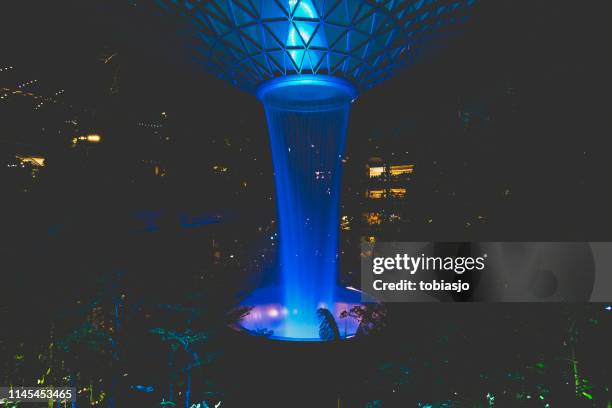 the rain vortex waterfall located inside the jewel changi airport in singapore - changi stock pictures, royalty-free photos & images