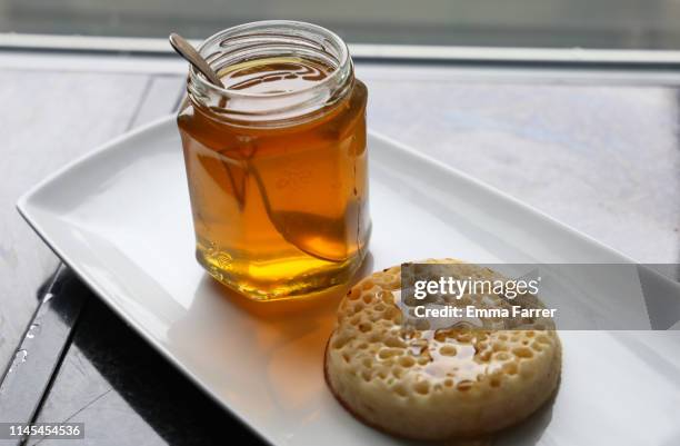 jar of honey next to crumpet - crumpet fotografías e imágenes de stock