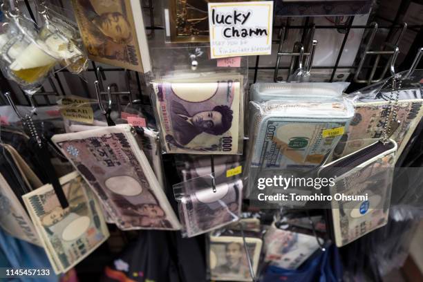 Wallets with images of Japanese yen banknotes are displayed for sale outside a store in the Asakusa area on the first day of the Golden Week holiday...