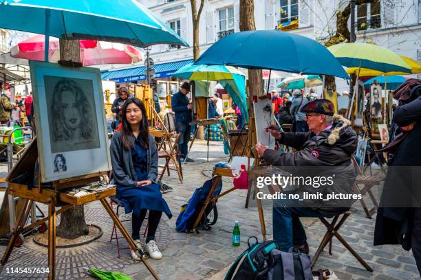 een jonge pirl poseren voor straat kunstenaar op montmartre in parijs, frankrijk - montmartre stockfoto's en -beelden