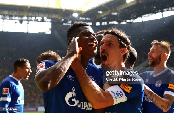 Breel Embolo of FC Schalke 04 celebrates with teammate Benjamin Stambouli after scoring his team's fourth goal during the Bundesliga match between...