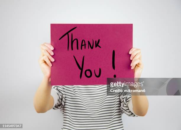 woman showing a paper page saying thank you - thank you fotografías e imágenes de stock