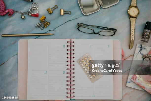 contraceptive pills , calendar and feminine items in desktop - oestrogen stock pictures, royalty-free photos & images