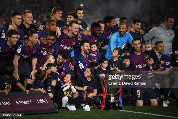 The FC Barcelona players pose with the La Liga trophy following their victory in the La Liga match between FC Barcelona and Levante UD at Camp Nou on...