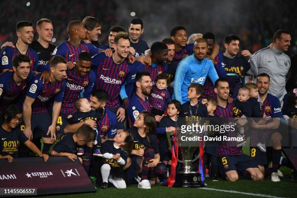 The FC Barcelona players pose with the La Liga trophy following their victory in the La Liga match between FC Barcelona and Levante UD at Camp Nou on...
