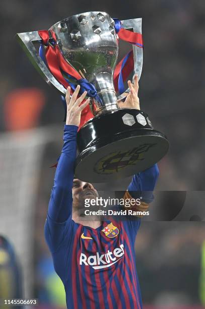 Lionel Messi of FC Barcelona celebrates with the La Liga trophy following his team's victory in the La Liga match between FC Barcelona and Levante UD...