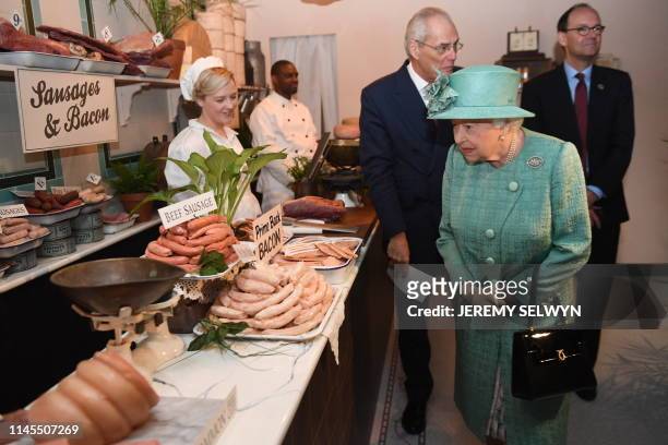 Britain's Queen Elizabeth II views a butchers meat counter during a visit to a replica of one of the original Sainsbury's stores in Covent Garden in...
