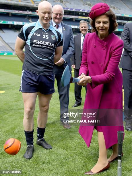 Sweden's Queen Silvia tries her hand at hurling, at Croke Park, the home of the Gaelic Athletic Association , in Dublin on May 22 on the first day of...