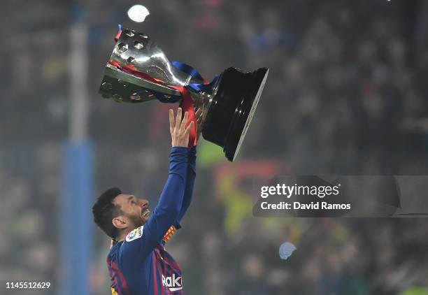 Lionel Messi of FC Barcelona celebrates with the La Liga trophy following his team's victory in the La Liga match between FC Barcelona and Levante UD...