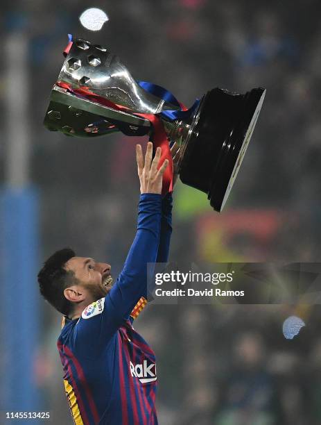 Lionel Messi of FC Barcelona celebrates with the La Liga trophy following his team's victory in the La Liga match between FC Barcelona and Levante UD...