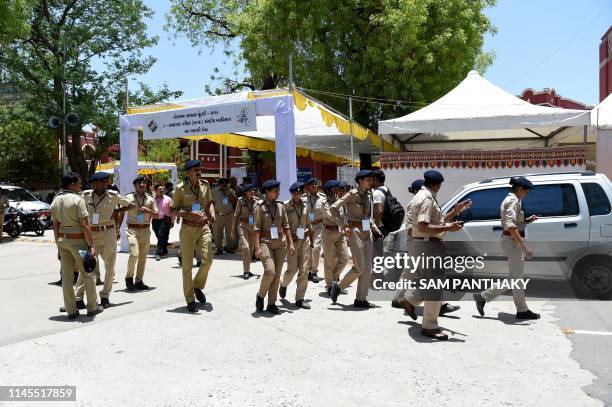 Gujarat state police officials walk in the premises at a counting centre on the eve of vote counting day of India's general election in Ahmedabad on...