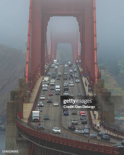fog engulfs the golden gate bridge - engulfs stock pictures, royalty-free photos & images