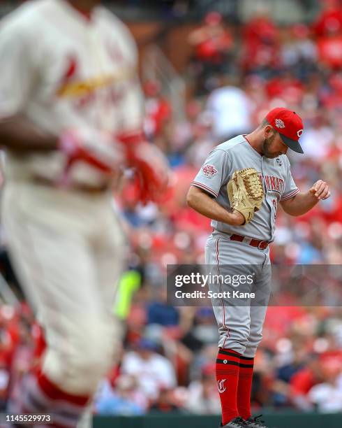 Zach Duke of the Cincinnati Reds pauses on the mound as Dexter Fowler of the St. Louis Cardinals runs to first base after being hit by a pitch from...