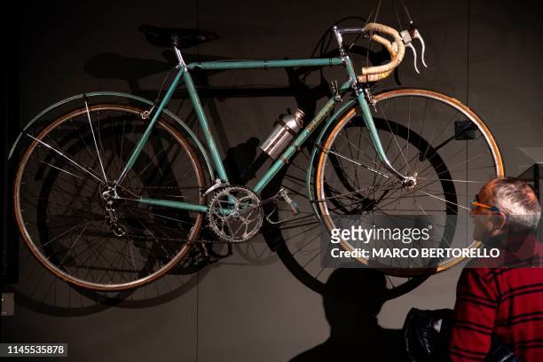 Man looks at an old Bianchi bicycle as he visit the exhibition " Fausto Coppi 9h19'55'' " at the Complesso Monumentale of San Francesco in Cuneo, on...