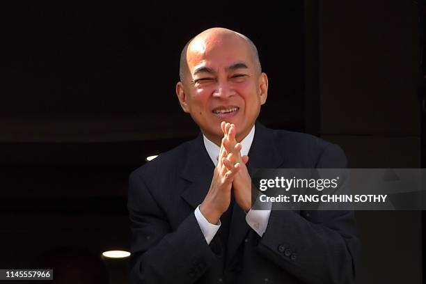 Cambodia's King Norodom Sihamoni gestures from the plane as he prepares to depart for France from Phnom Penh International Airport on May 23, 2019. -...