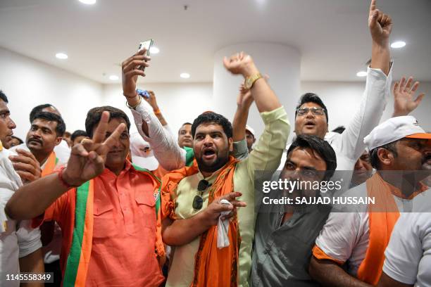 Indian Bharatiya Janata Party supporters shout slogans as they celebrate on the vote results day for India's general election at BJP headquarters in...